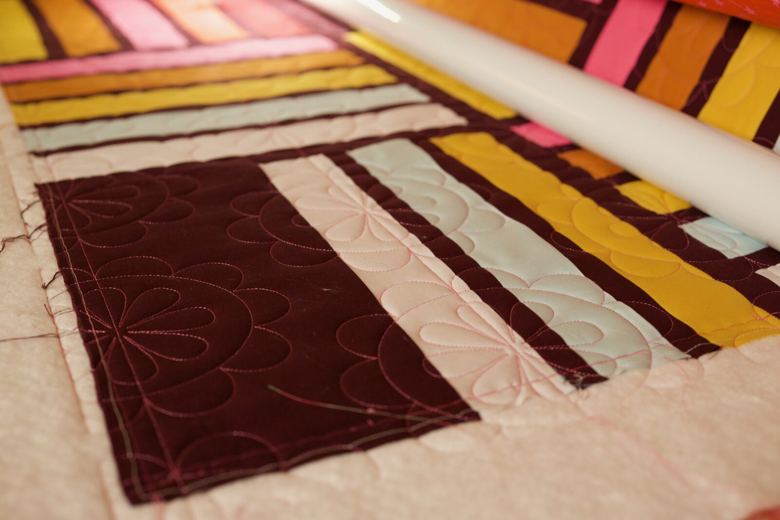 Petal quilting detail on cream, blush, and mint fabric stripes
