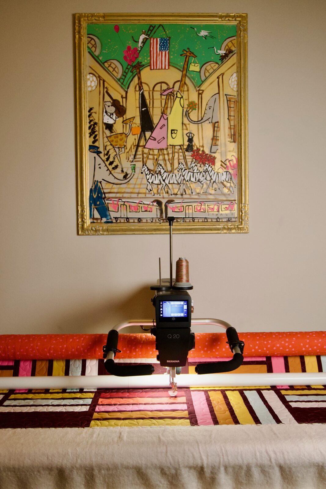 Longarm machine on the frame with a colorful quilt underneath