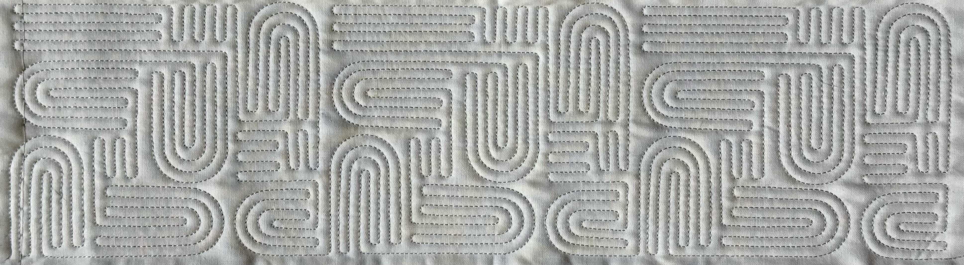 Detail of dense freehand maze-pattern quilting on cream fabric