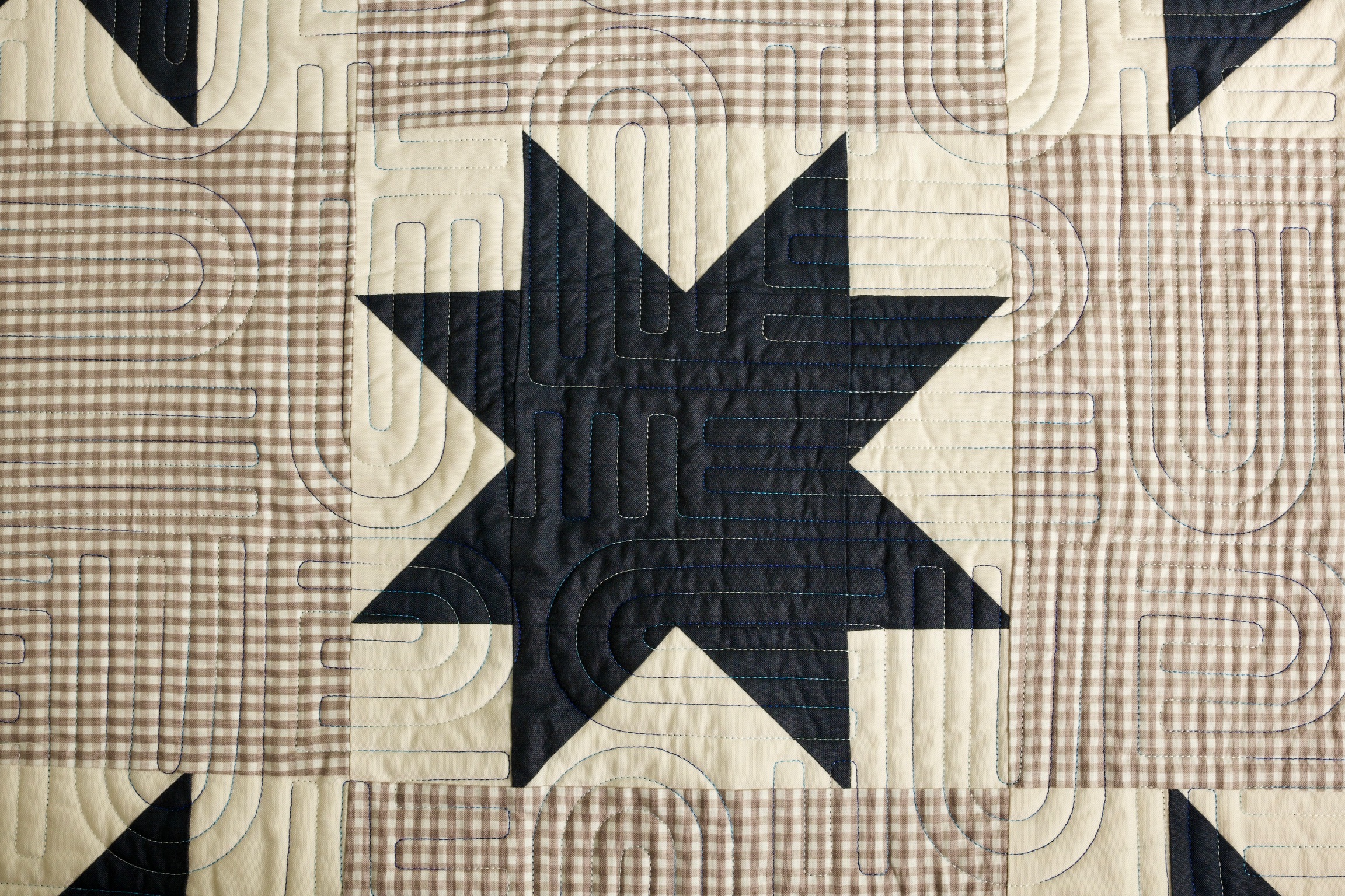Navy star quilt block set in cream and taupe gingham, with dense loop quilting