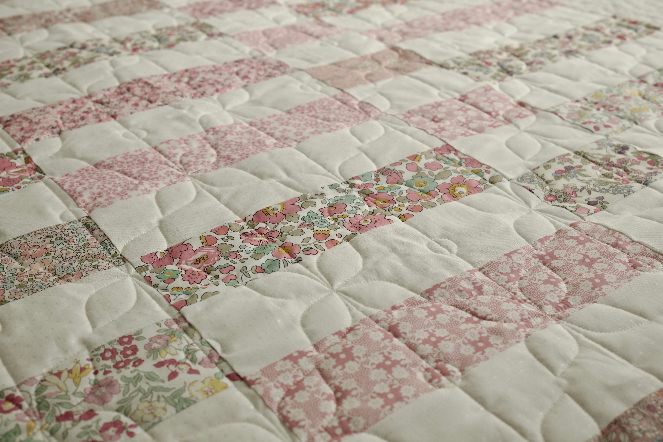 Soft pink floral stripe patchwork with petal quilting detail
