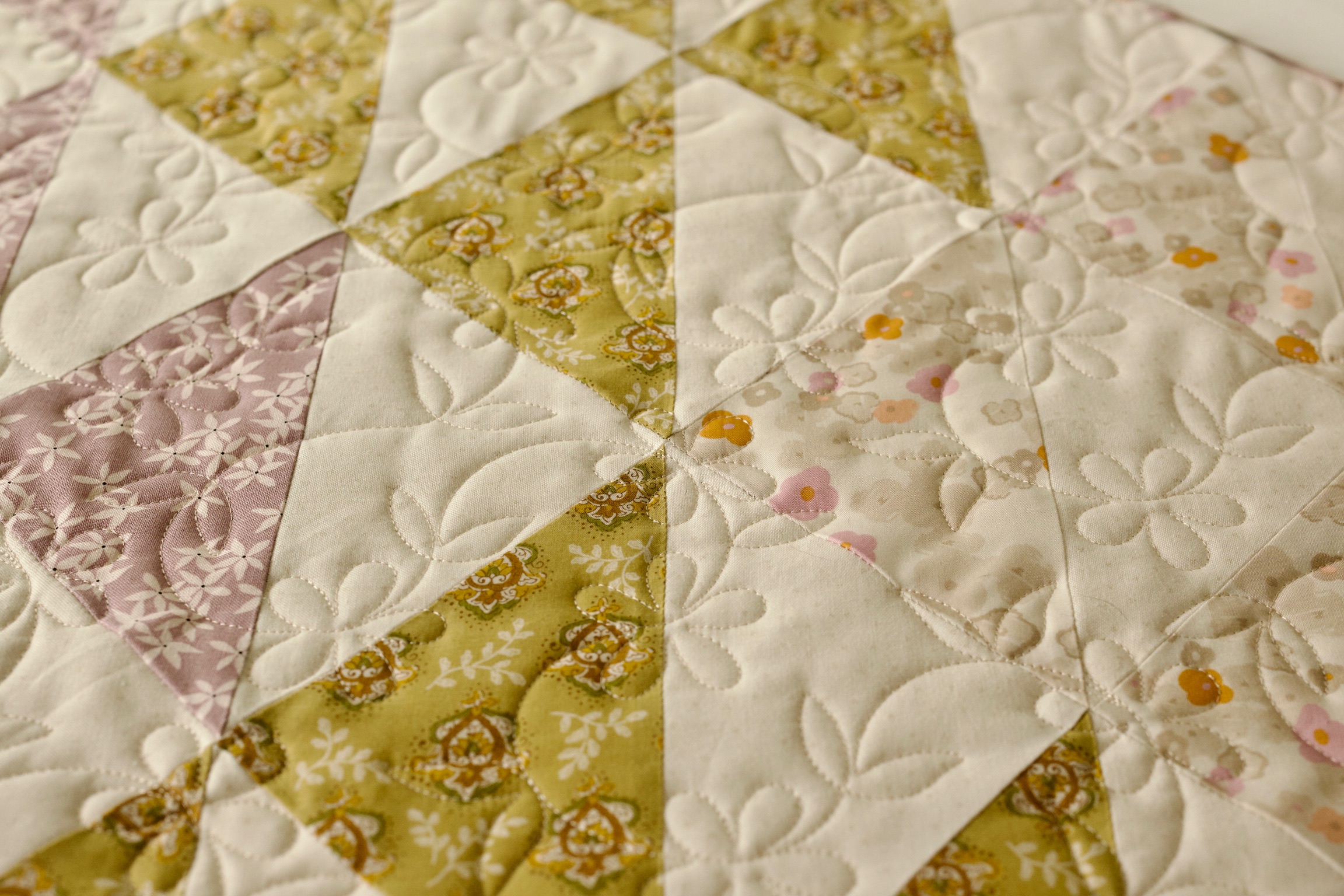 Floral triangle patchwork corner detail in blush, olive, and cream prints