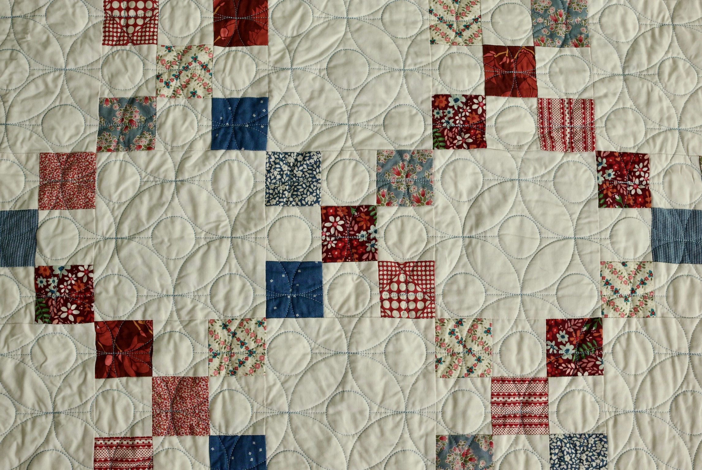 Close-up of scrappy floral squares in a red, white, and blue patchwork