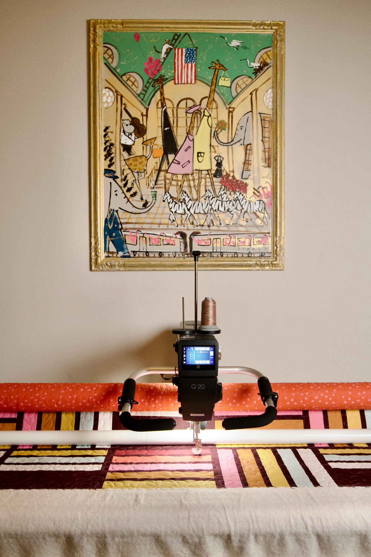 Longarm machine on the frame with a colorful quilt underneath