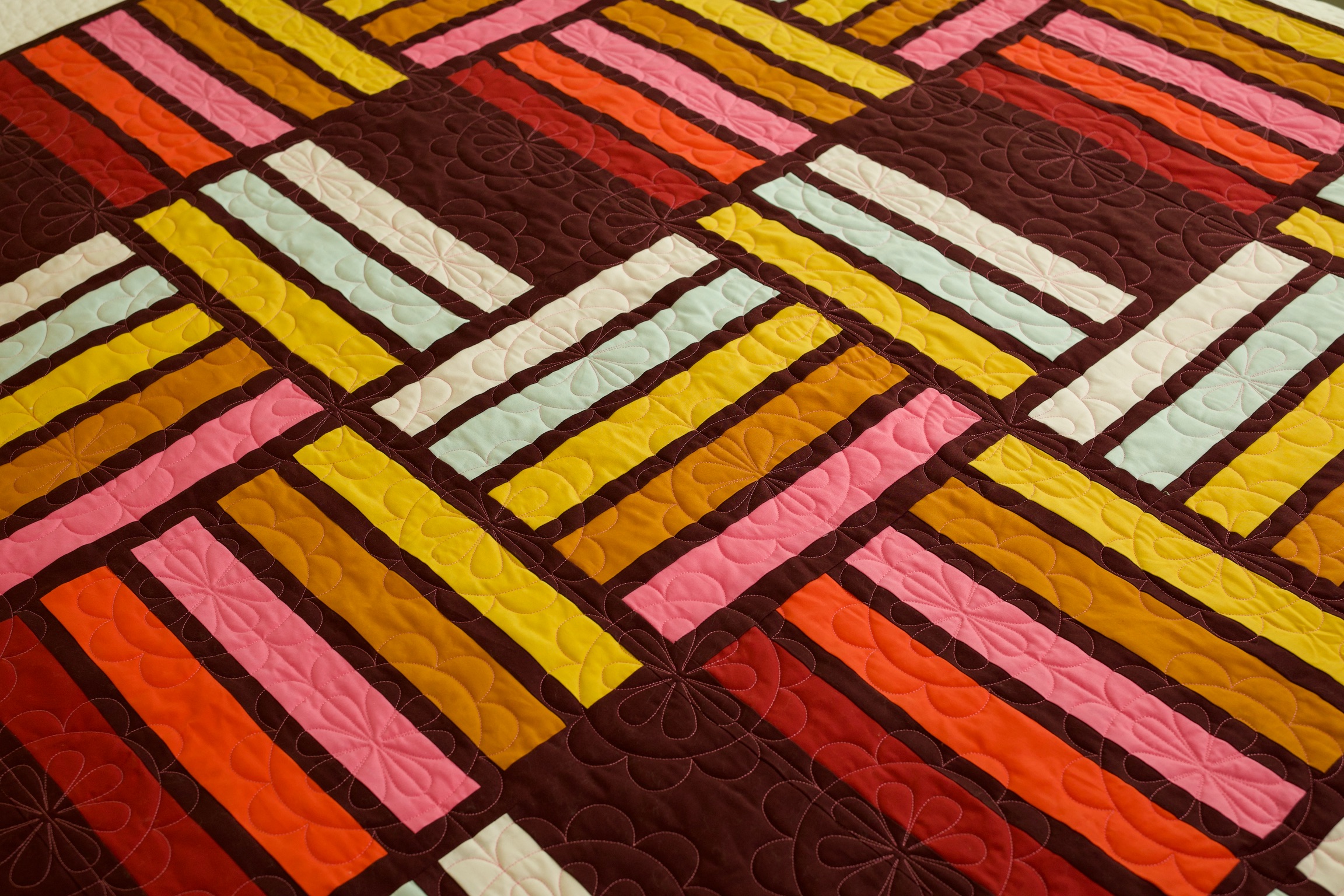 Close-up of woven rectangle patchwork in mustard, pink, and mint